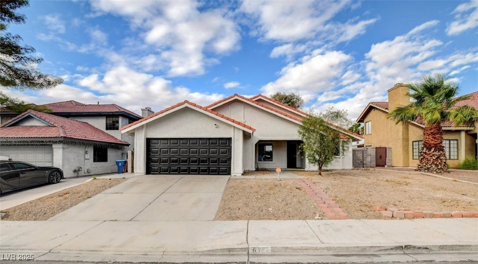 View of front facade with concrete driveway, stucco siding, and an attached garage