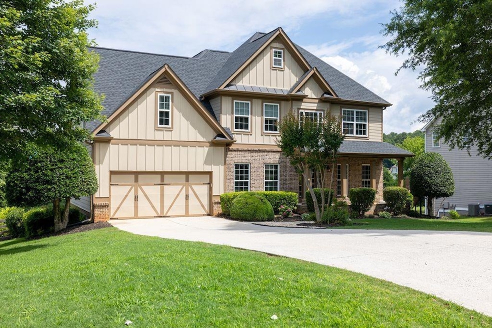 Craftsman house with brick siding, concrete driveway, roof with shingles, a front lawn, and board and batten siding