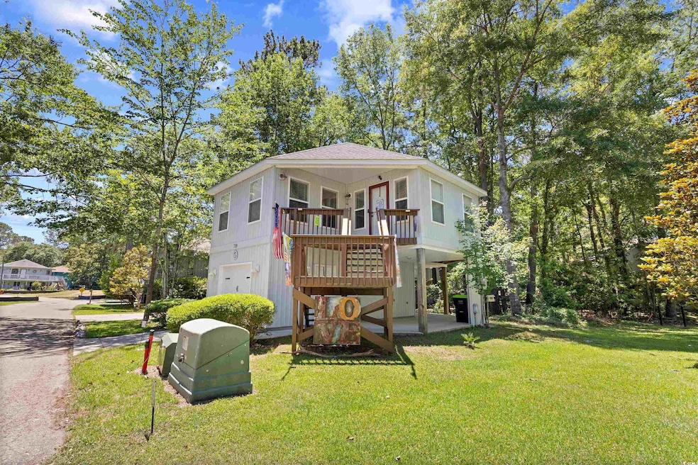 View of front facade featuring a front yard and a wooden deck