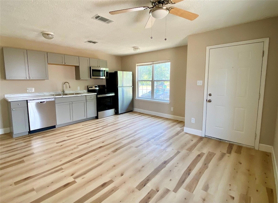 Kitchen featuring gray cabinetry, appliances with