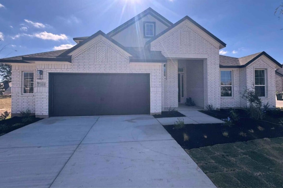 View of front facade featuring driveway, a garage