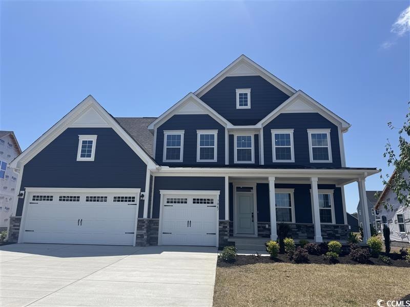 Craftsman-style house with a garage, driveway, a p