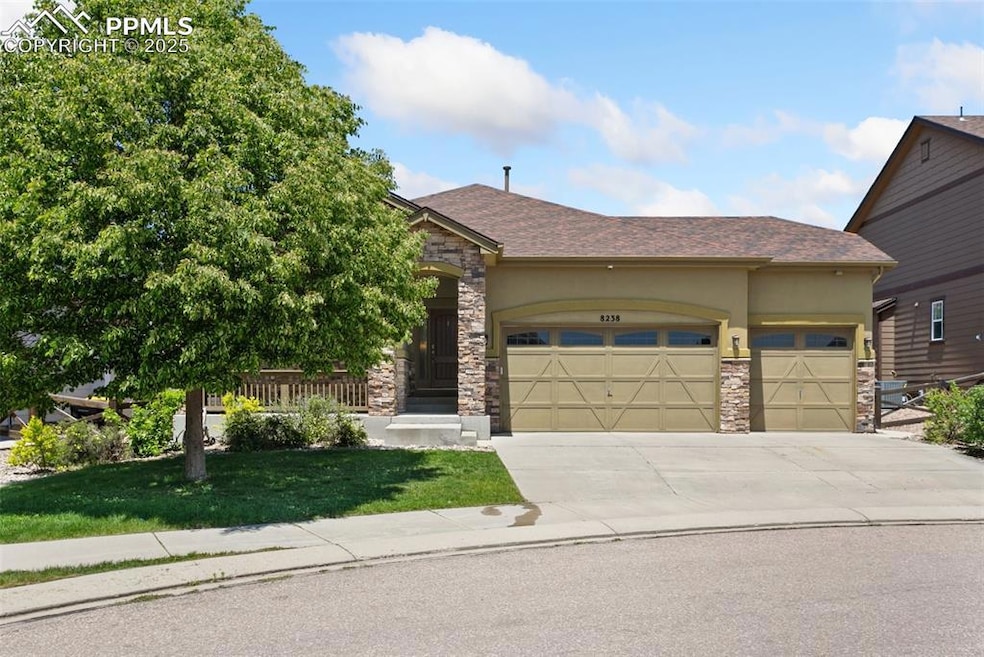 View of front of house with stucco siding and stone trim.