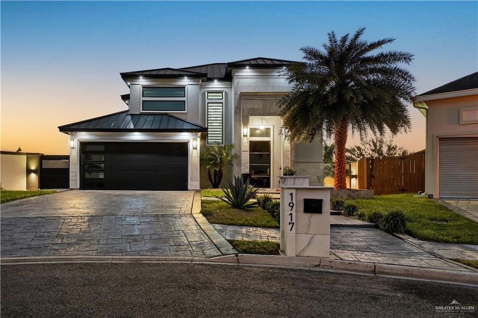View of front of property featuring a standing seam roof, a metal roof, decorative driveway, and a garage