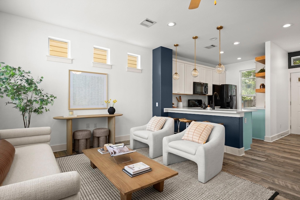 Living room with dark wood-style flooring, basebo