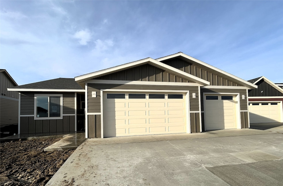 View of front of home with board and batten siding, a shingled roof, driveway, and a garage
