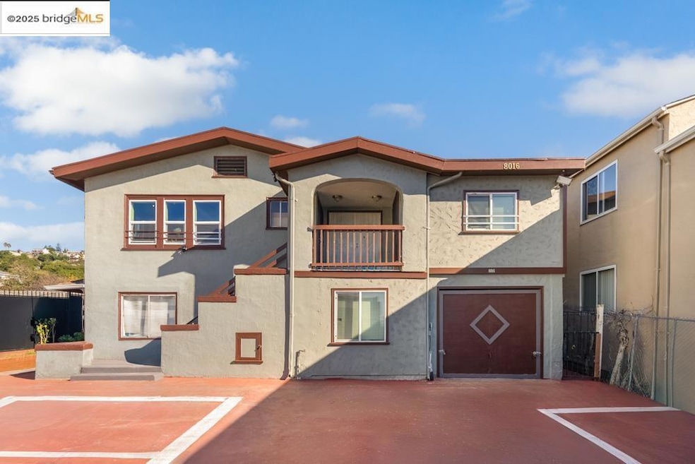 View of front of property with stucco siding and a balcony
