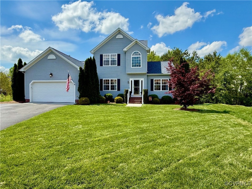 Transitional home with a front lawn, asphalt drive