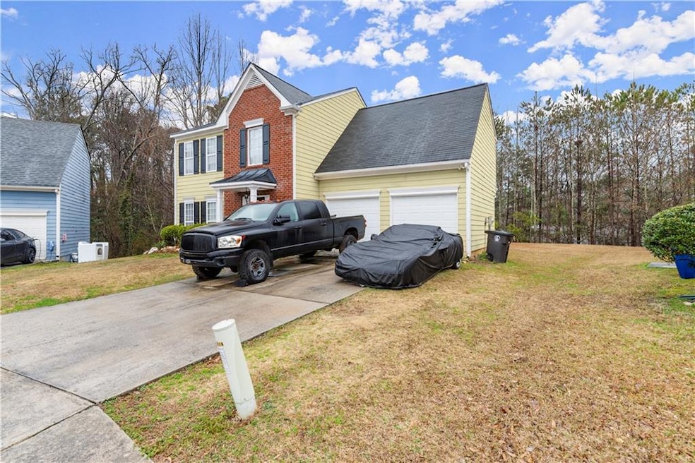 View of side of home with roof with shingles, a ya
