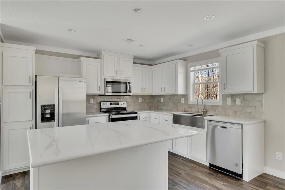Kitchen with stainless steel appliances, white cab