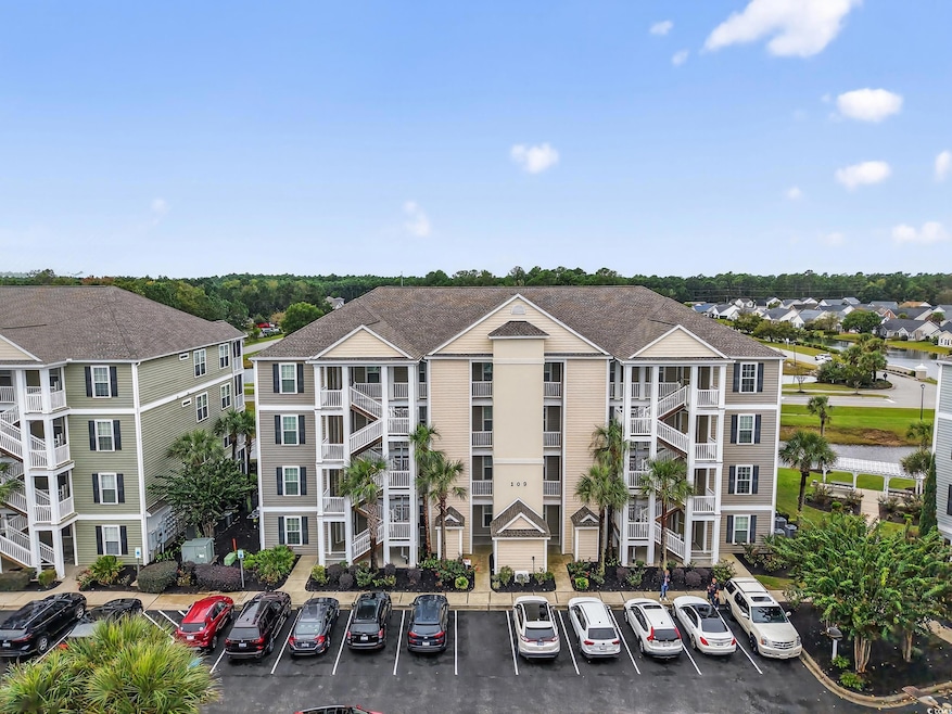 View of apartment building / complex with uncovered parking