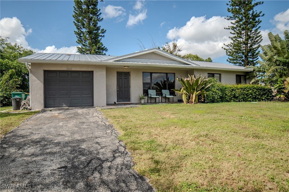 Single story home featuring a front lawn and a gar