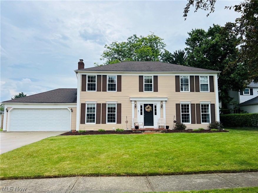 Colonial house featuring a garage and a front yard