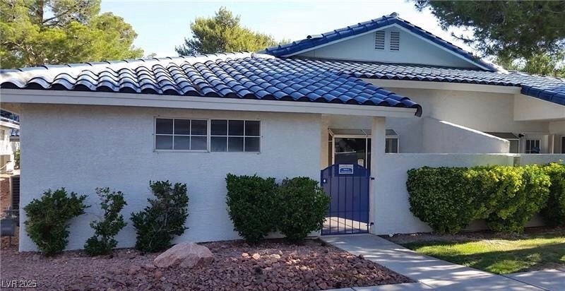View of front of property with a gate, a tile roof
