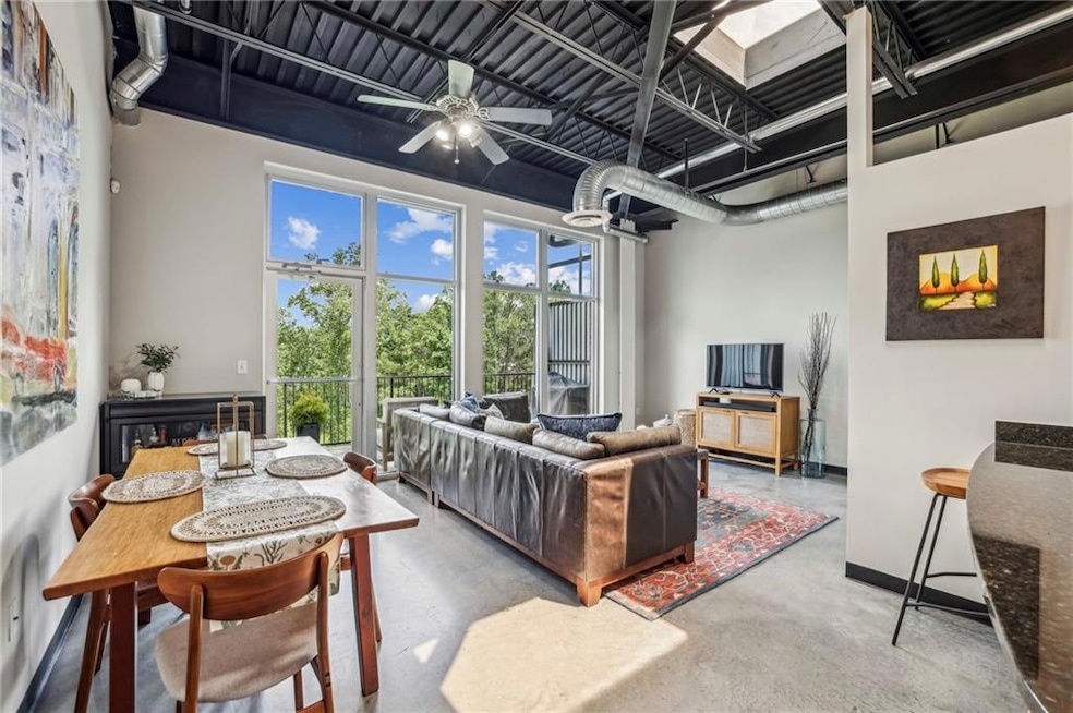 Living room with concrete floors, ceiling fan, and baseboards