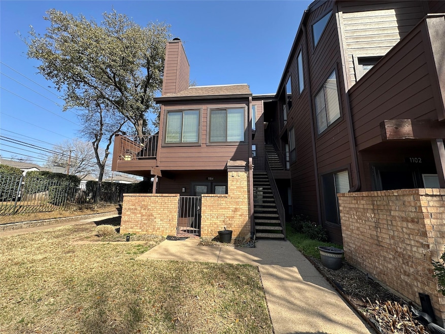 Back of house with a chimney, fence, brick siding,