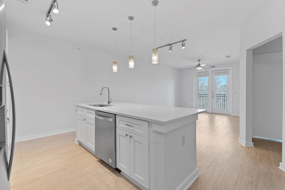 Kitchen featuring track lighting, appliances with