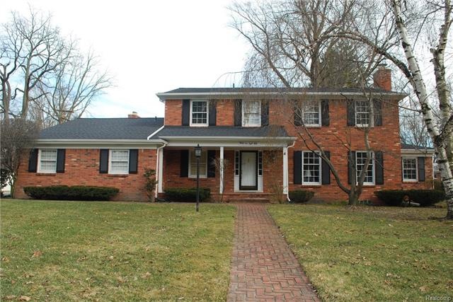 Stately colonial with brick walkway and inviting f