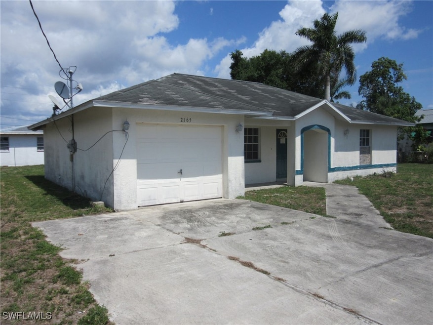 Ranch-style house with stucco siding, a garage, dr