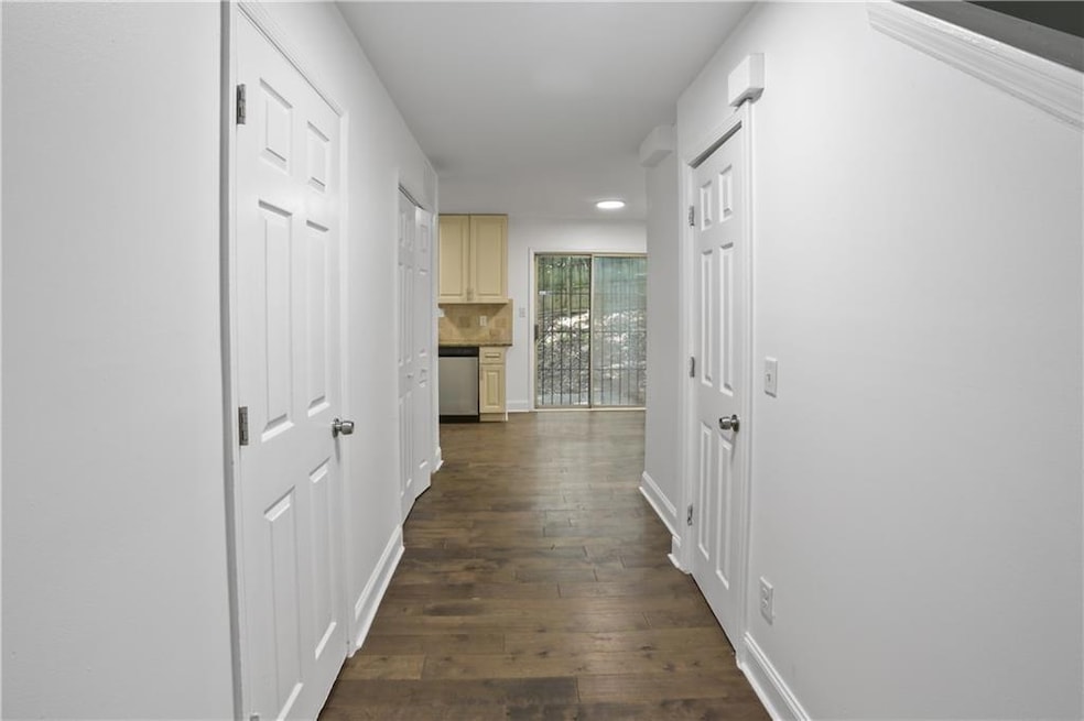 Corridor featuring dark wood-type flooring and baseboards