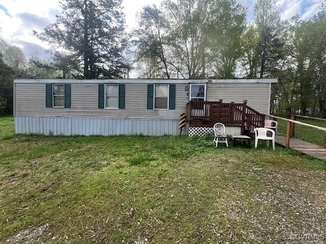 View of front facade featuring a deck and a front lawn