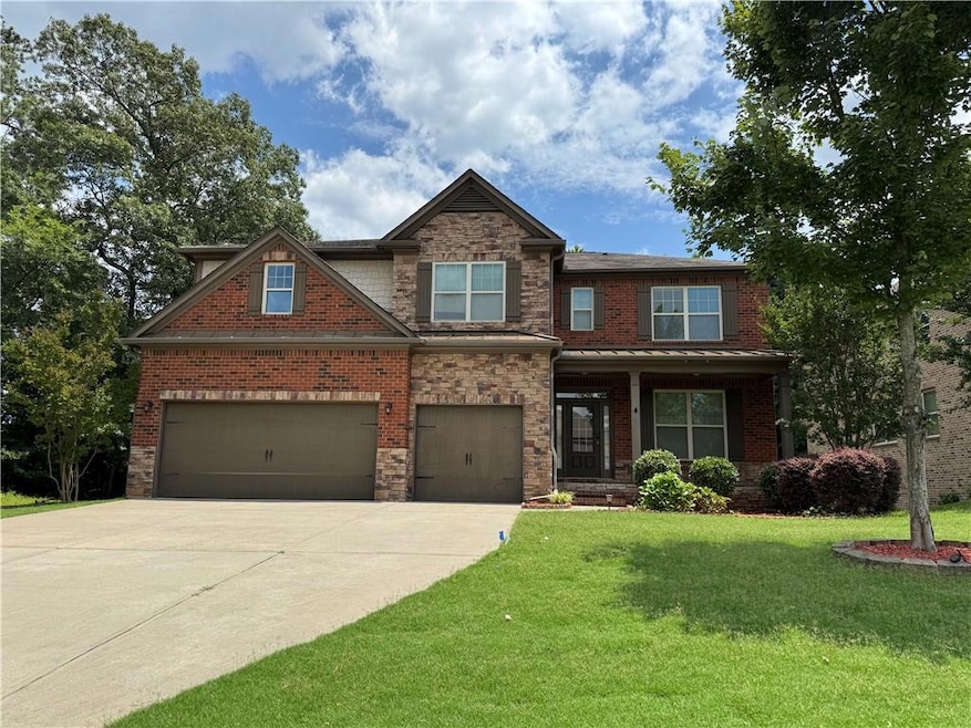 Craftsman house with concrete driveway, a front lawn, an attached garage, and brick siding