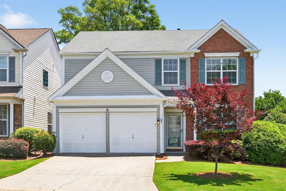 Traditional-style home with concrete driveway, a front lawn, and brick siding