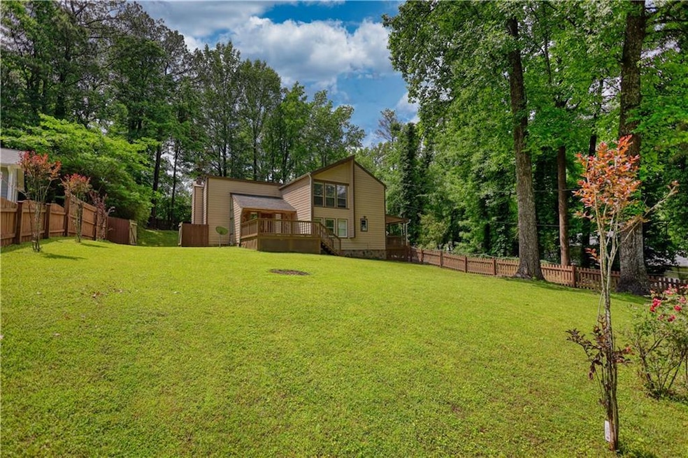 View of yard with a deck and view of wooded area