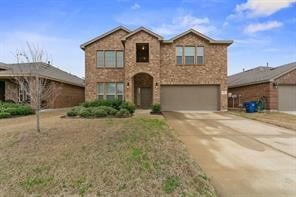 Traditional home with concrete driveway, an attached garage, and brick siding