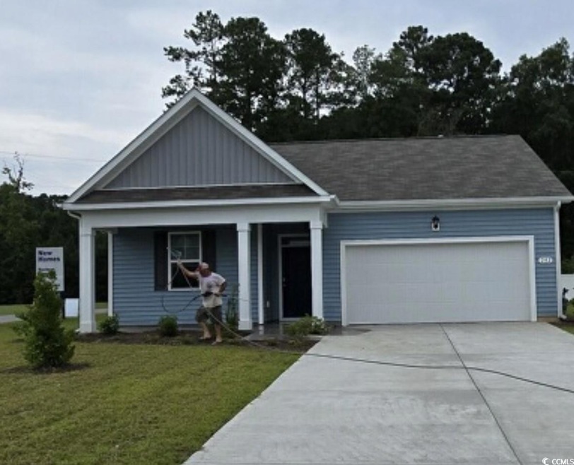 View of front of house with a garage and a front y