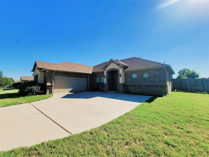 View of front of home with brick siding, driveway, and a garage