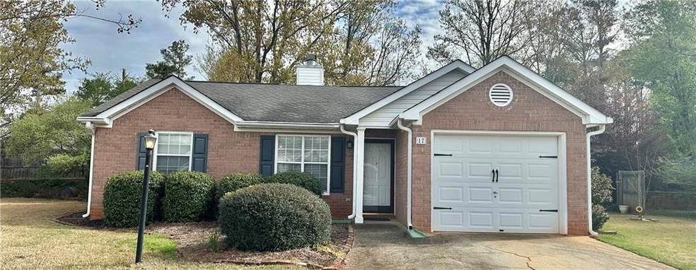 Single story home with a garage and a front yard
