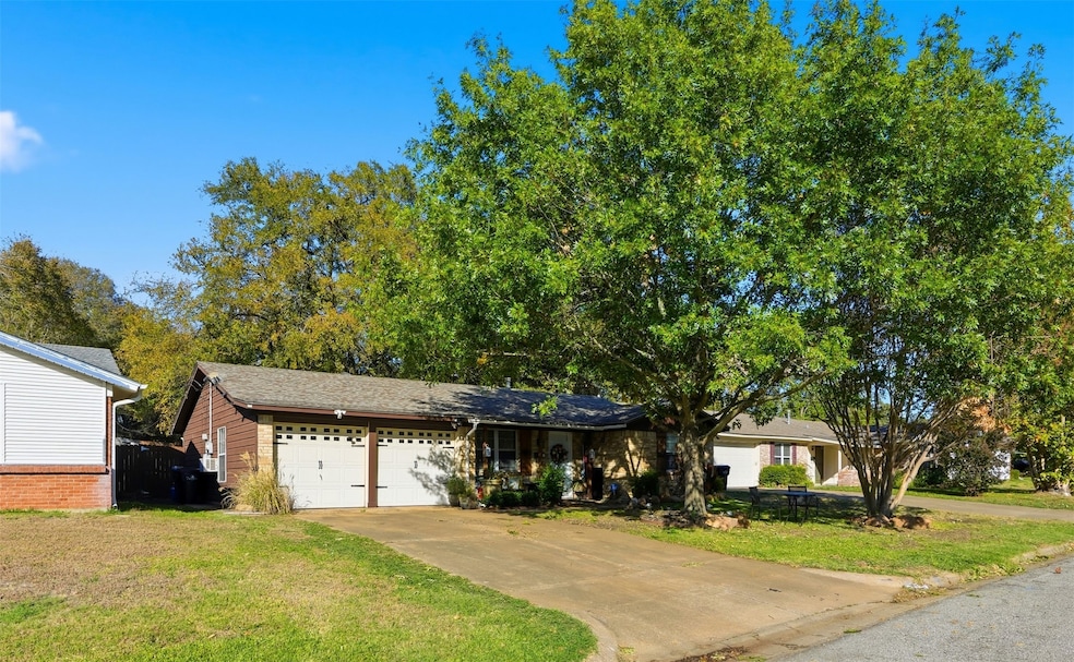 View of front facade featuring a front lawn, driveway, and an attached garage