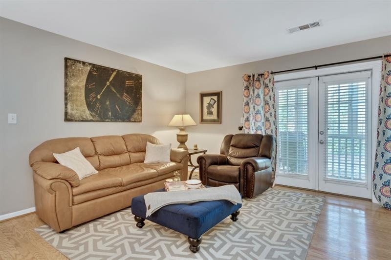 Open living room features hardwood floors and door