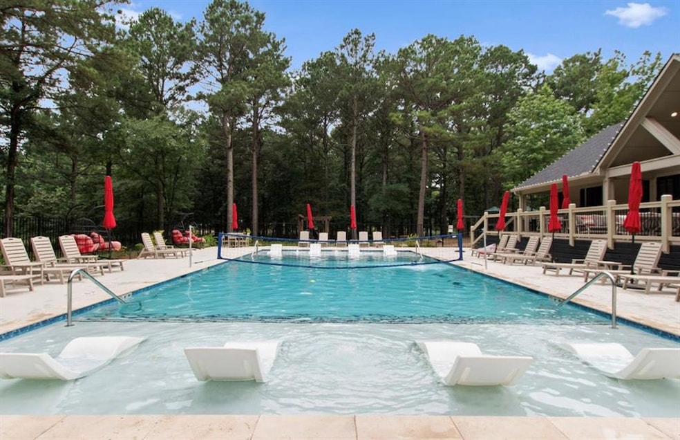 Community pool with a patio and view of scattered trees