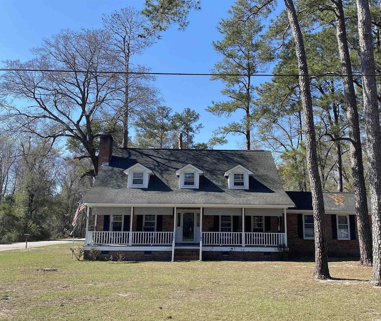 Cape cod-style house with a front yard, covered porch, and crawl space
