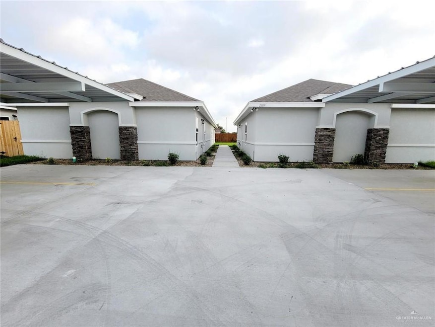 View of home's exterior featuring stone siding, stucco siding, and roof with shingles