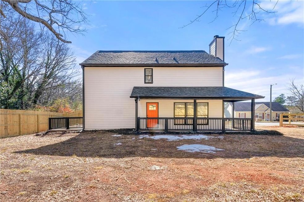 Rear view of property with a porch, a chimney, and