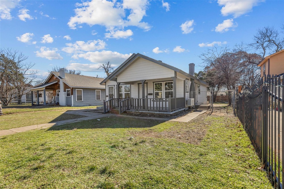 Back of property featuring a porch and a yard