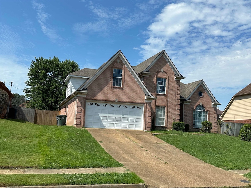 Front facade featuring a front yard and a garage