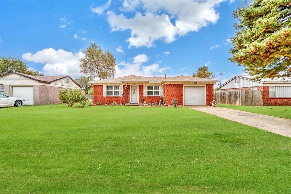Ranch-style home featuring a garage and a front ya