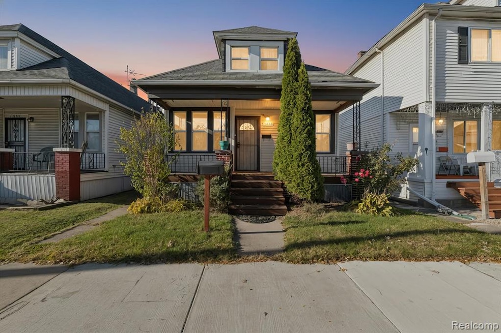 Bungalow-style home featuring covered porch, a front yard, and a shingled roof