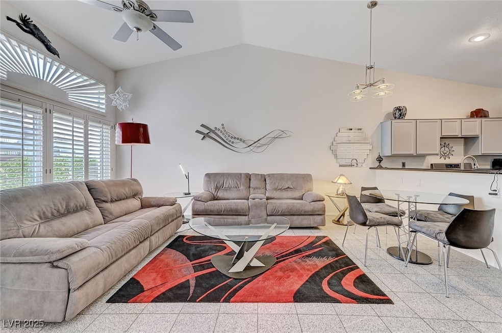 Living area featuring lofted ceiling, a ceiling fa