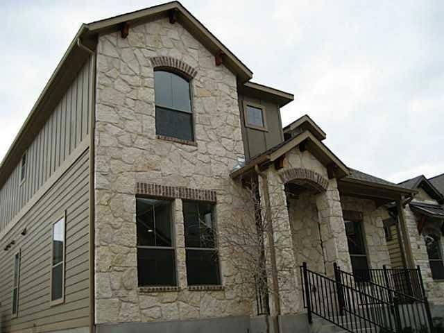View of side of home featuring stone siding and b