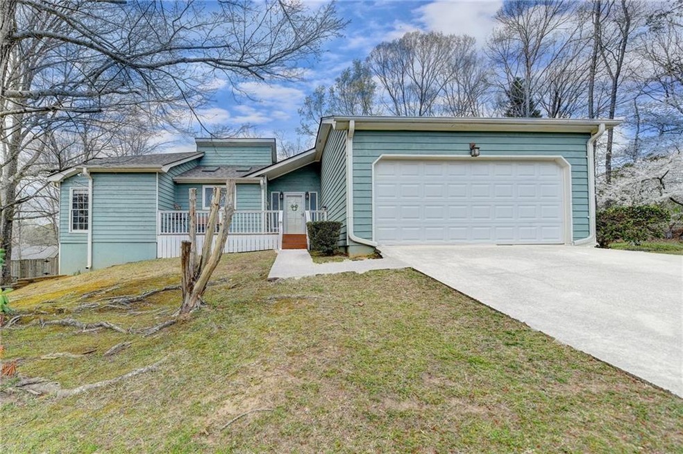 View of front of house with a front yard, an attac