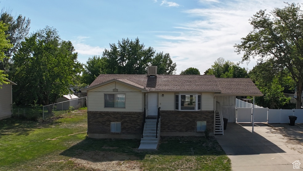 Ranch-style home featuring brick siding, driveway, a chimney, a gate, and central AC unit