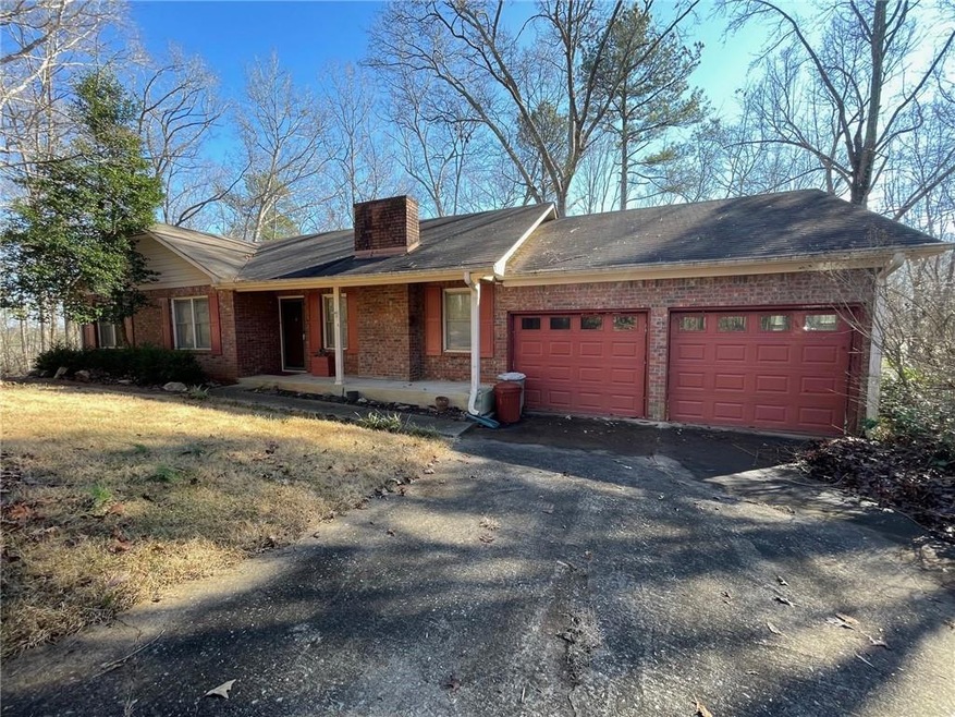 Ranch-style house featuring covered porch and a ga