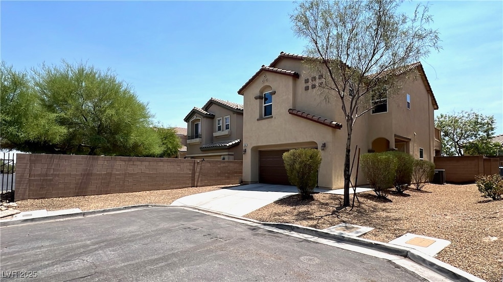 View of side of home with a garage, driveway, stuc
