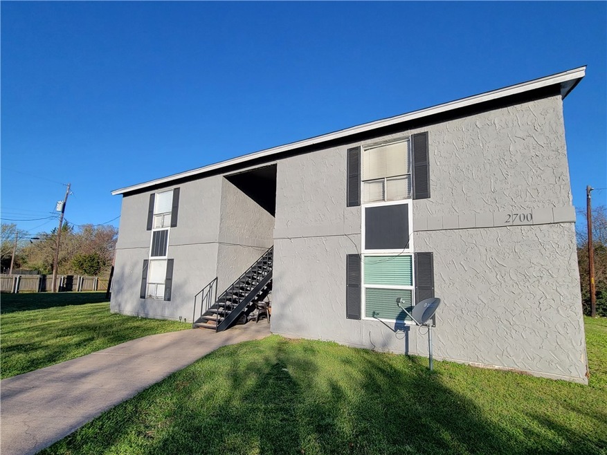 View of side of property with a yard, stairs, and