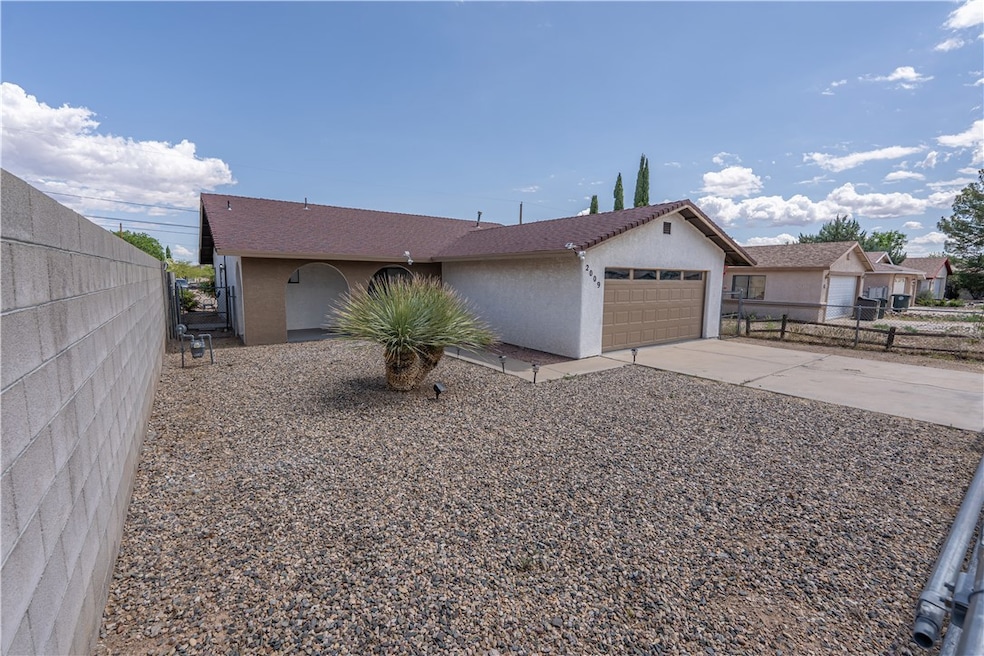 View of front of home with stucco siding, an attac